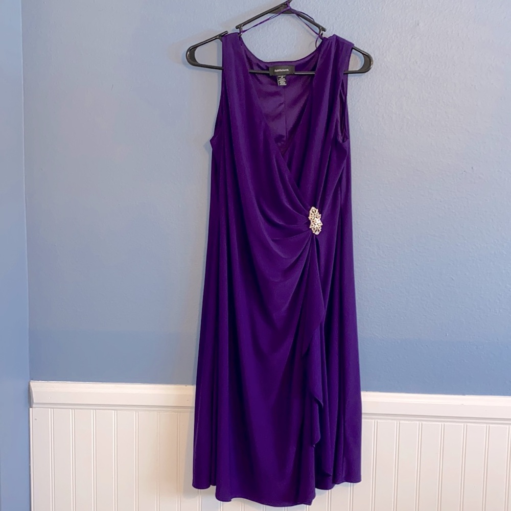 Purple dress with brooch, sleeveless, length below knee. Size 14